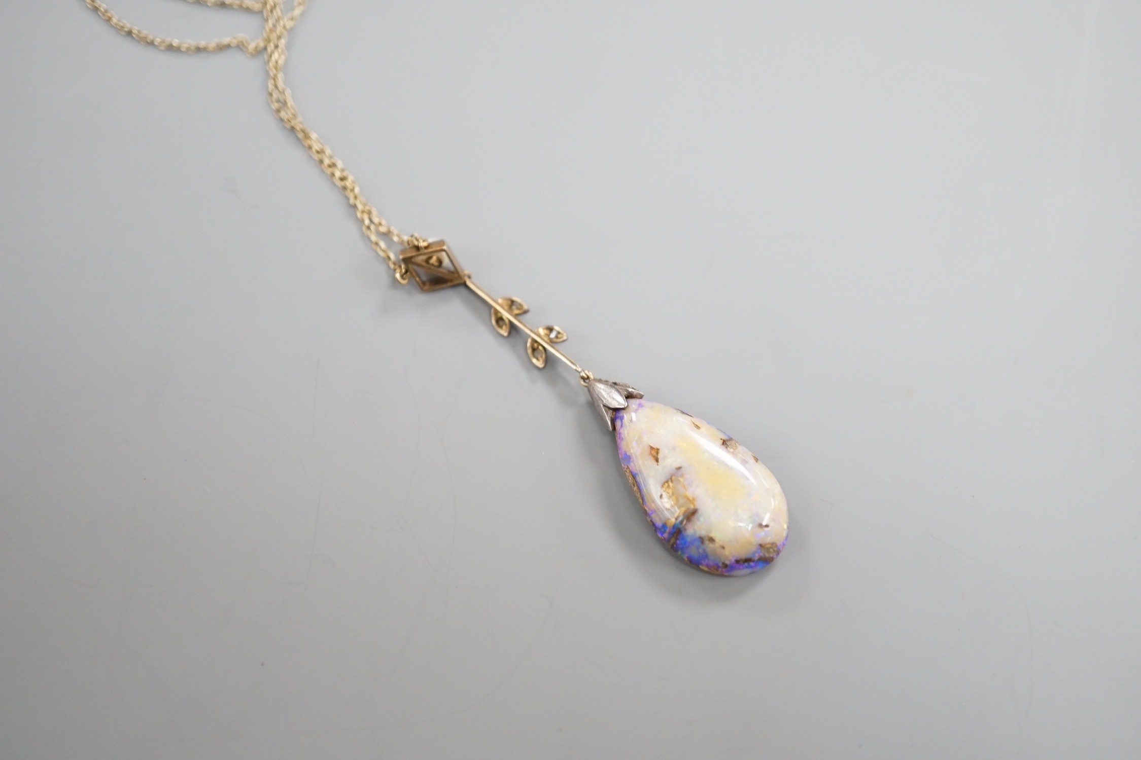 An early 20th century yellow and white metal, pear shaped black opal, rose cut diamond and seed pearl set drop pendant necklace, pendant overall 57mm, chain stamped 9ct, 37cm, gross weight 5.9 grams.